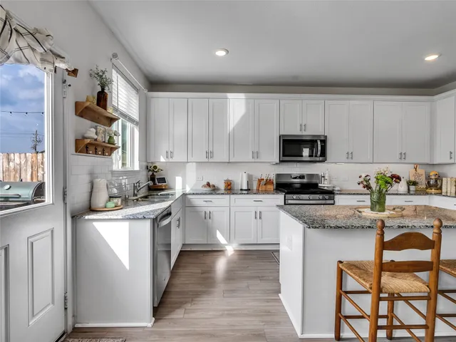 a kitchen with stainless steel appliances granite countertop a stove a sink dishwasher and a refrigerator