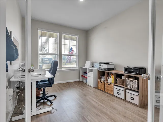 a view of a workspace with furniture and a window