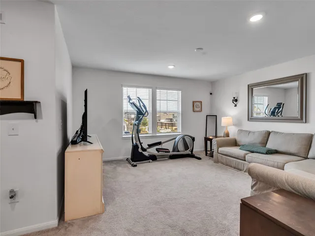 a living room with furniture a window and a flat screen tv