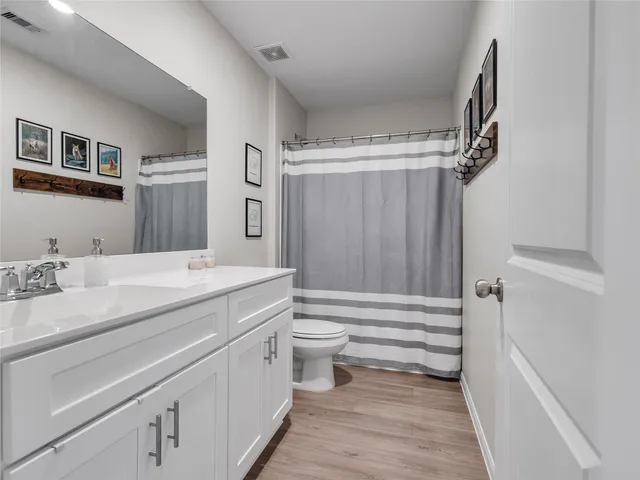 a bathroom with a granite countertop sink toilet and shower