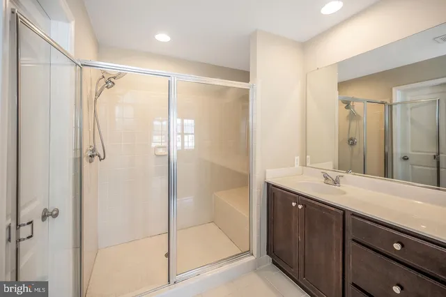 a bathroom with a shower sink and mirror