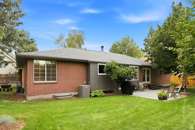 2073 Village Point Way Sandy, UT 84093 - Photo 63 of 68 Expansive backyard featuring a large paver patio, brick exterior wall, mature trees, manicured lawn, and fully fenced yard. Perfect for entertaining!