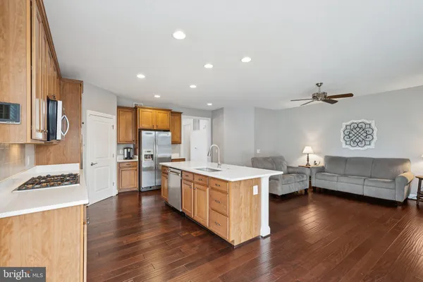 a kitchen that has a lot of cabinets in it and wooden floor