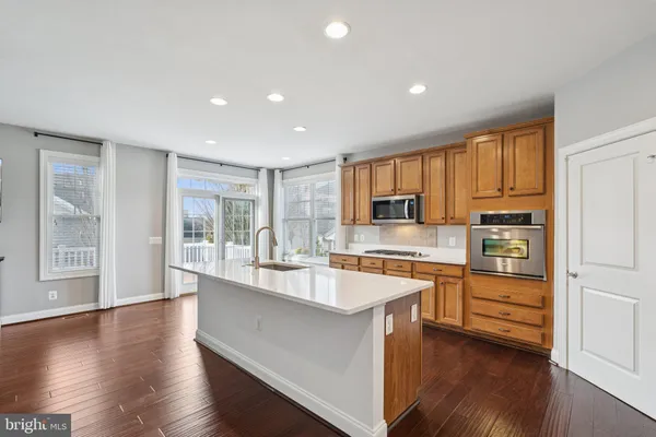 a large kitchen with stainless steel appliances granite countertop a large window and a sink