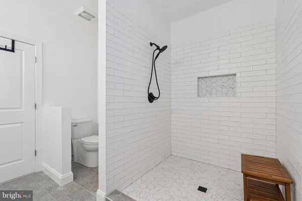 a bathroom with a granite countertop shower a toilet and a sink