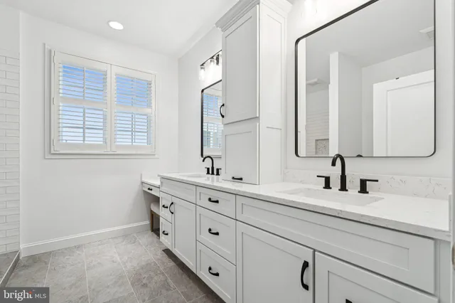 a bathroom with double sink and a mirror