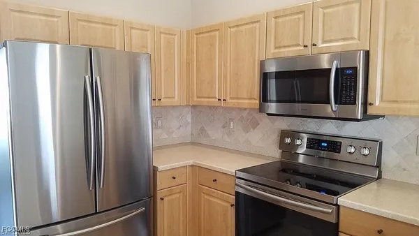 a kitchen with granite countertop a refrigerator stove and microwave