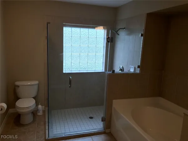 a bathroom with a bathtub toilet and window