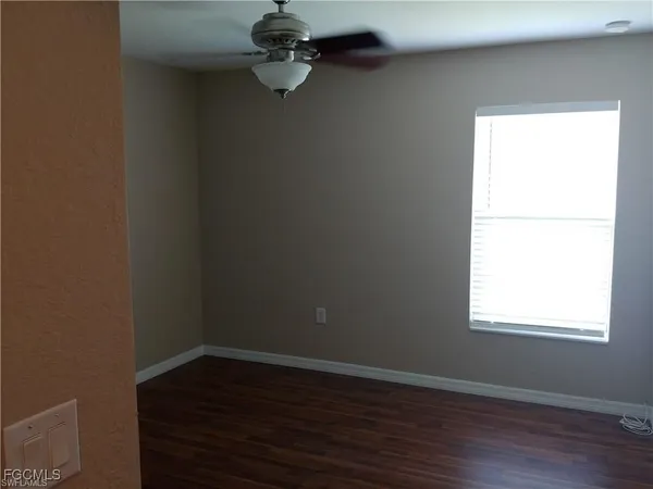 a view of a small space with wooden floor and a window