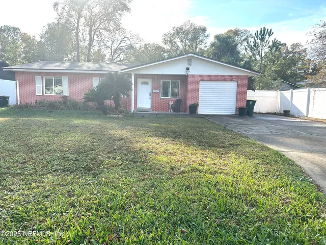 a view of a yard in front of a house with large trees