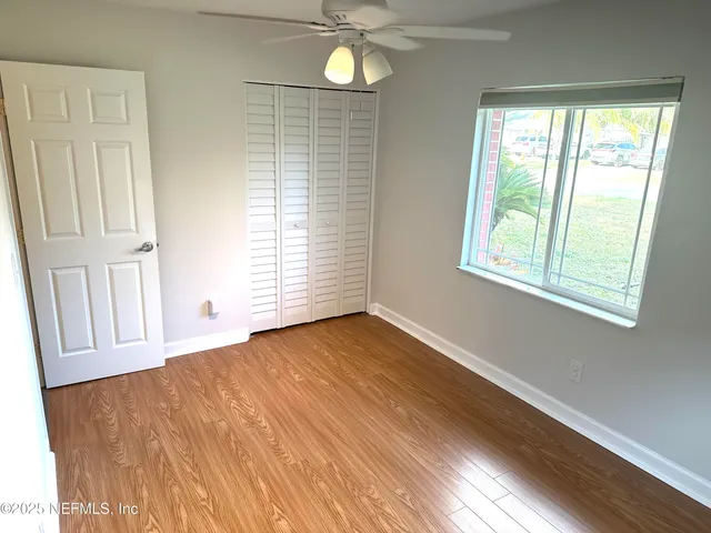 an empty room with wooden floor and windows