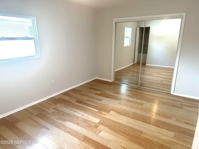 a view of empty room with wooden floor