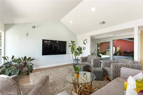 a kitchen with a stove a sink a dining table and chairs with wooden floor