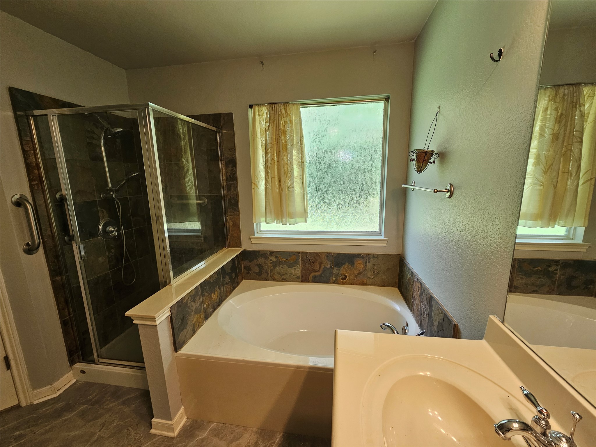 2035 Intrepid Drive Buda, TX 78610 - Photo 14 of 26 Luxurious bathing retreat boasts a soaking tub and a sleek glass-enclosed shower.