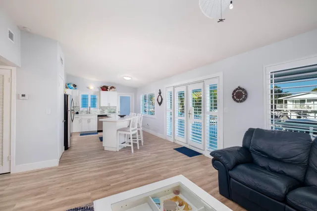 a living room with furniture floor to ceiling window and wooden floor