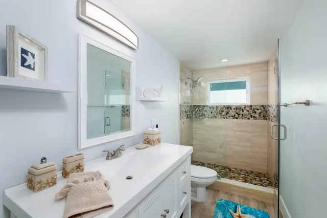 a bathroom with a sink a toilet and shower