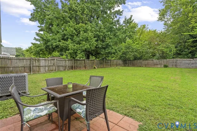 a view of a chairs and table in the back yard of a house