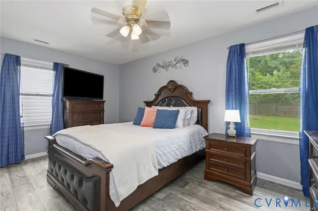 a bedroom with a bed and a dresser next to a window