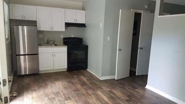 a kitchen with a refrigerator sink and cabinets