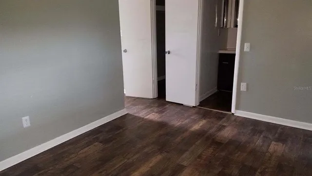 an empty room with wooden floor and closet