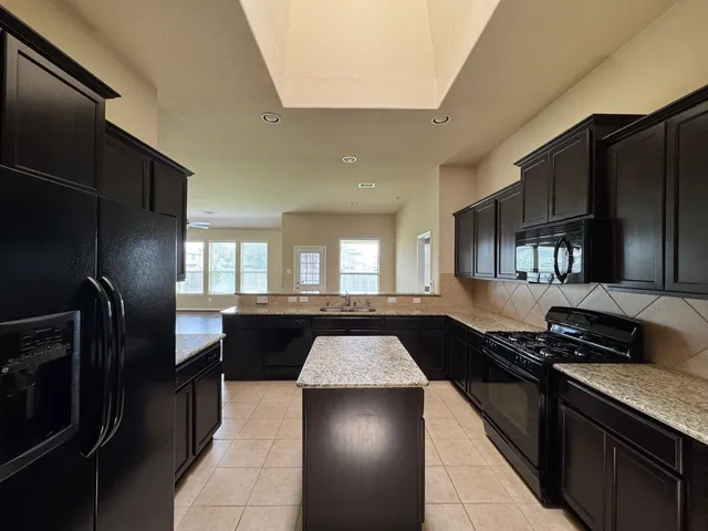 a kitchen with a refrigerator and a stove top oven