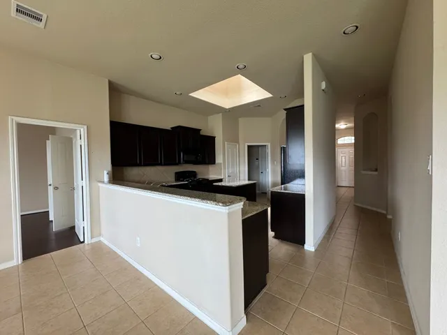 a kitchen with stainless steel appliances kitchen island granite countertop a refrigerator and a stove top oven