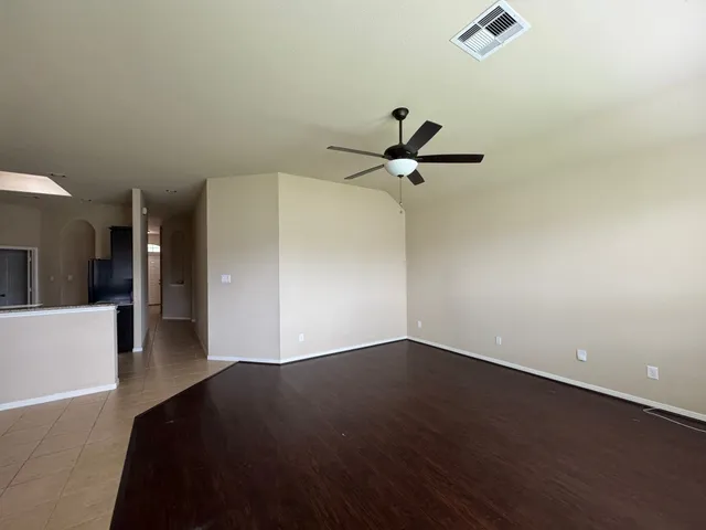 a view of a livingroom with wooden floor and a ceiling fan