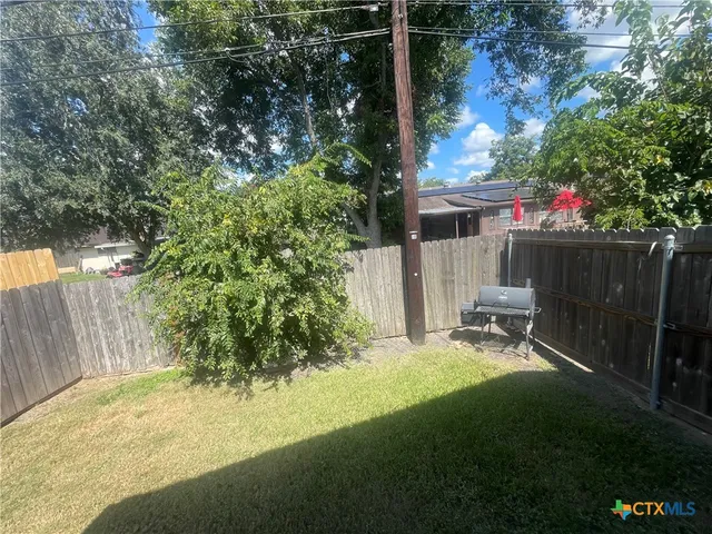 a view of backyard with table and chairs and potted plants