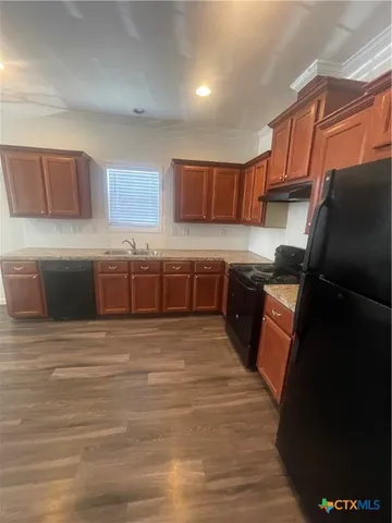 a kitchen with stainless steel appliances granite countertop a sink and a refrigerator