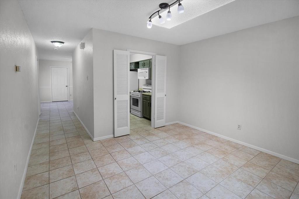 1903 Wyndemere Lane Garland, TX 75042 - Photo 11 of 28 en empty room with kitchen view