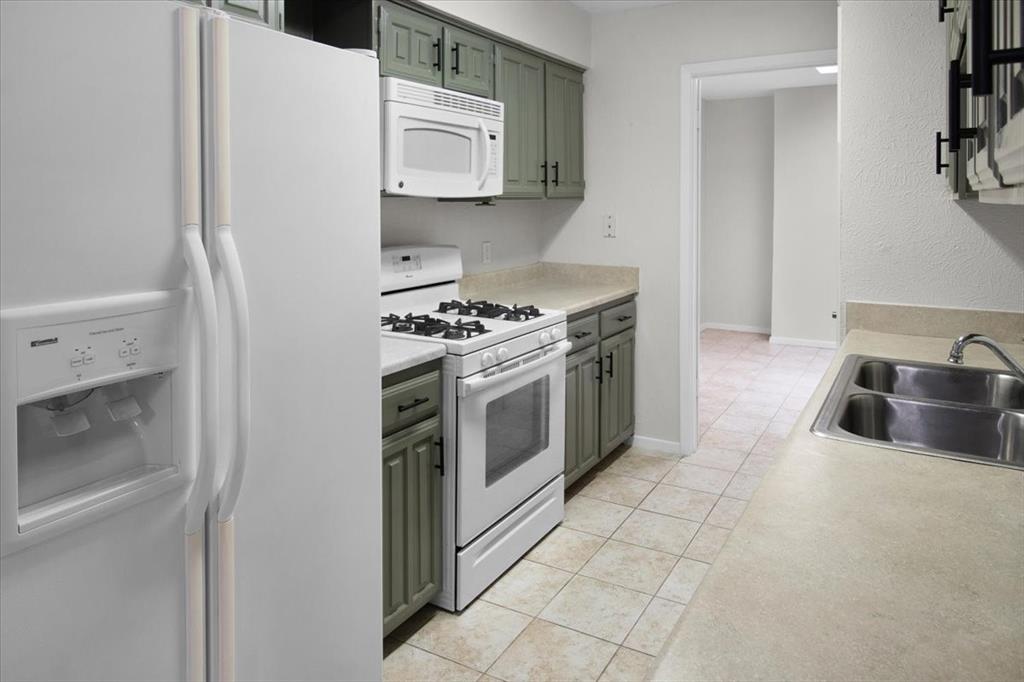 1903 Wyndemere Lane Garland, TX 75042 - Photo 14 of 28 a kitchen with stainless steel appliances granite countertop a stove a sink and a refrigerator
