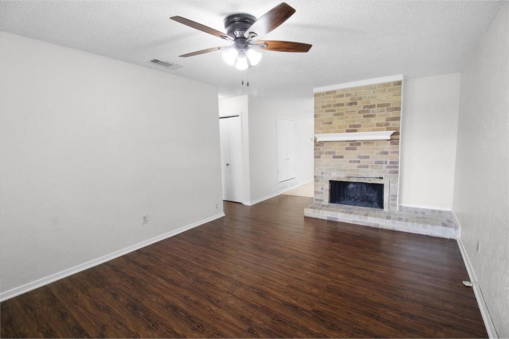 1903 Wyndemere Lane Garland, TX 75042 - Photo 2 of 28 wooden floor in an empty room with a fireplace
