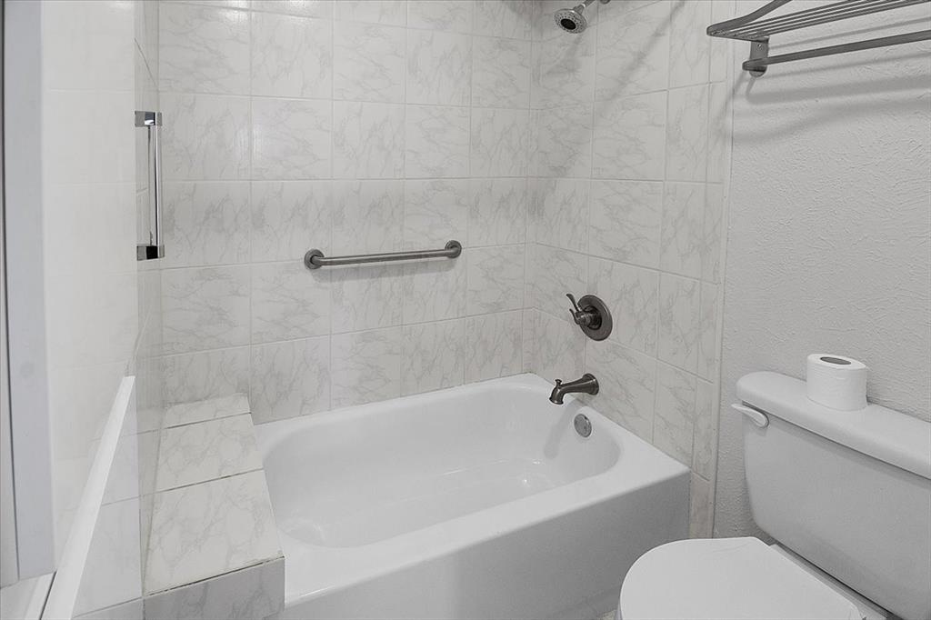 1903 Wyndemere Lane Garland, TX 75042 - Photo 25 of 28 a white bath tub sitting next to a white toilet