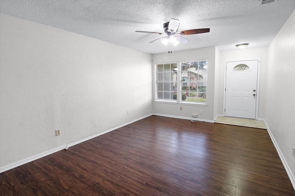 1903 Wyndemere Lane Garland, TX 75042 - Photo 3 of 28 a view of an empty room with wooden floor and a window