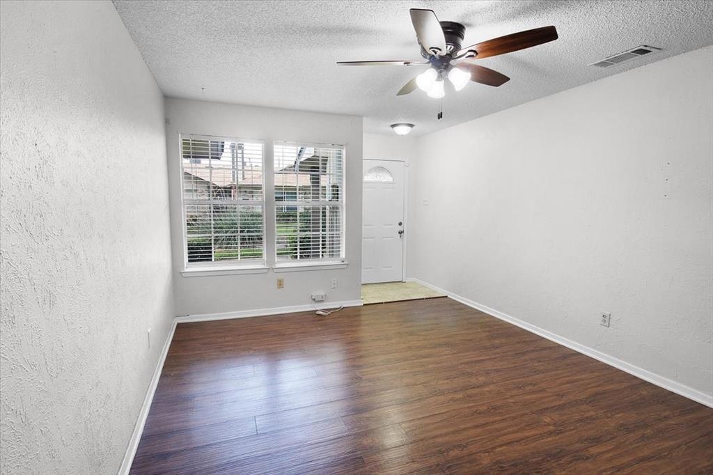 1903 Wyndemere Lane Garland, TX 75042 - Photo 4 of 28 wooden floor in an empty room with a window