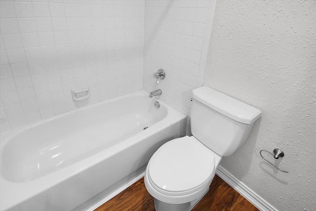 1903 Wyndemere Lane Garland, TX 75042 - Photo 9 of 28 a white toilet sitting next to a bath tub