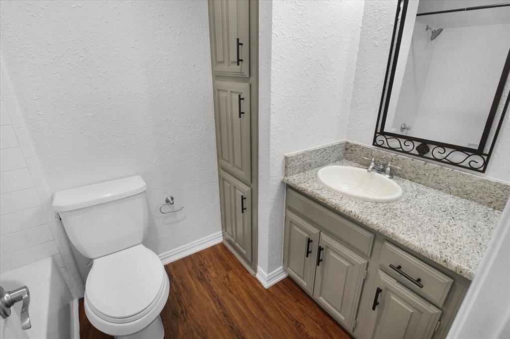1903 Wyndemere Lane Garland, TX 75042 - Photo 10 of 28 a bathroom with a granite countertop toilet sink and mirror