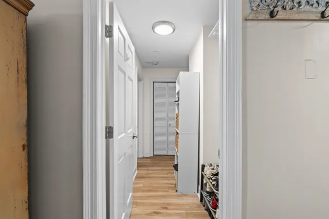 a view of a hallway with wooden floor and closet