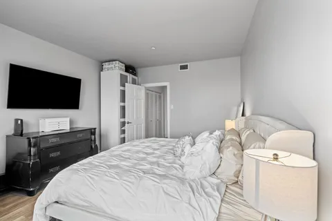a bedroom with a bed and a flat screen tv