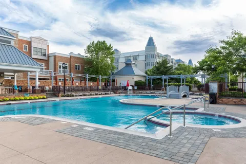 a view of a swimming pool with lawn chairs under an umbrella