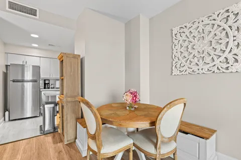 a view of a dining room with furniture and a refrigerator