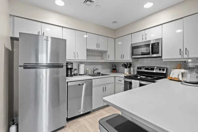 a kitchen with stainless steel appliances a refrigerator stove microwave and cabinets