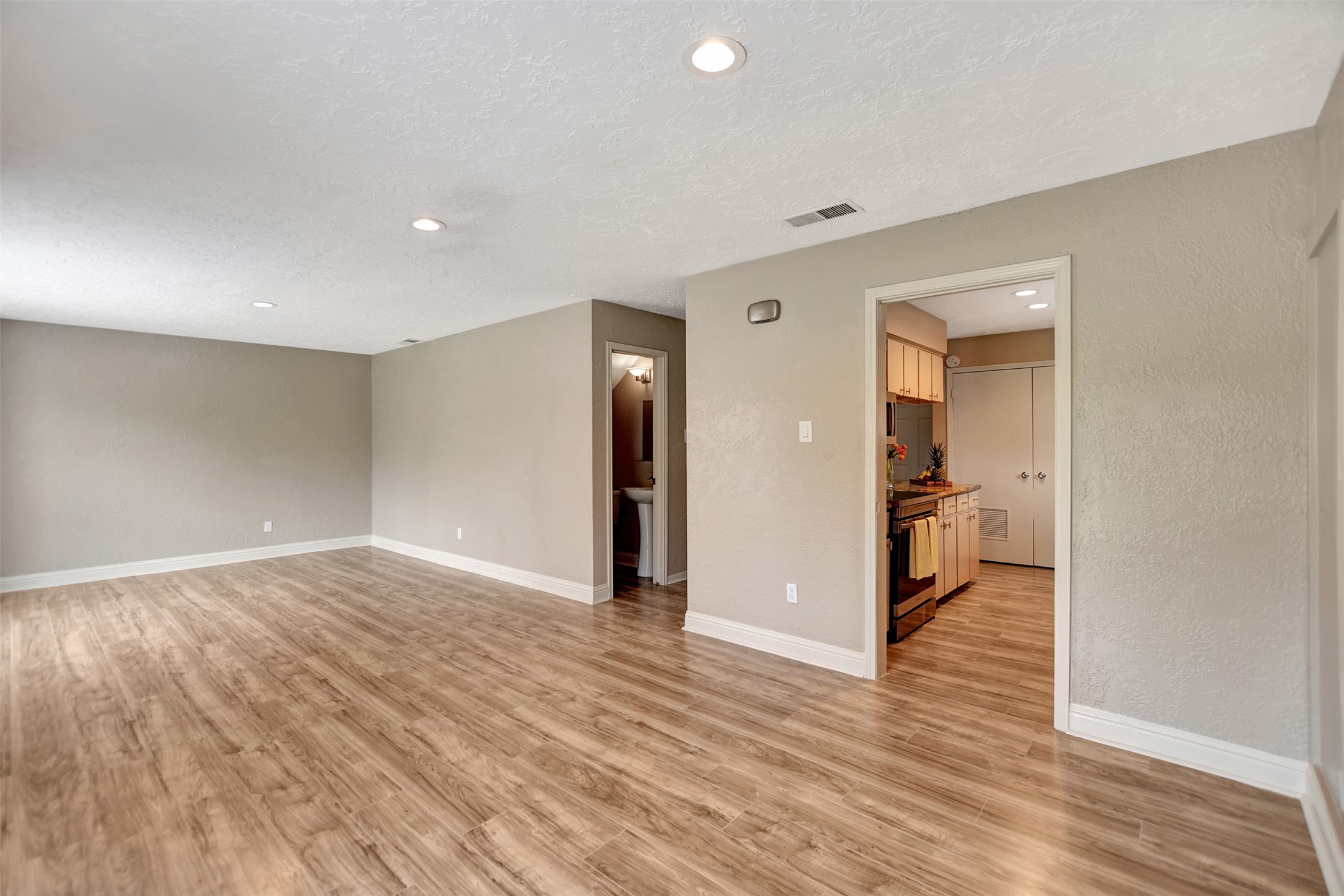3826 Willow Springs Lane, Unit 3826 Houston, TX 77080 - Photo 16 of 43 a view of a hallway with wooden floor and a kitchen space