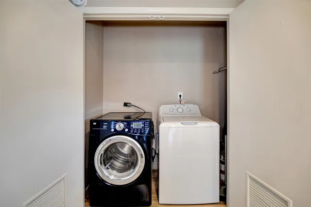 an empty room with windows fan and fireplace
