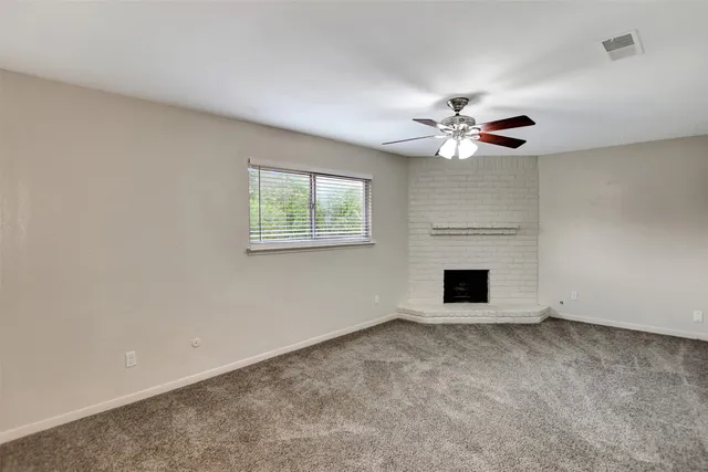 an empty room with windows and fireplace