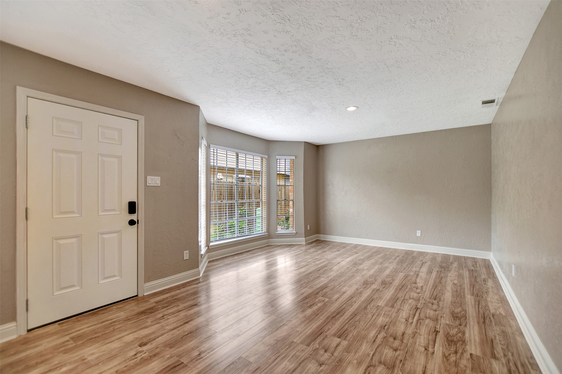 3826 Willow Springs Lane, Unit 3826 Houston, TX 77080 - Photo 8 of 43 a view of an empty room with wooden floor and a window