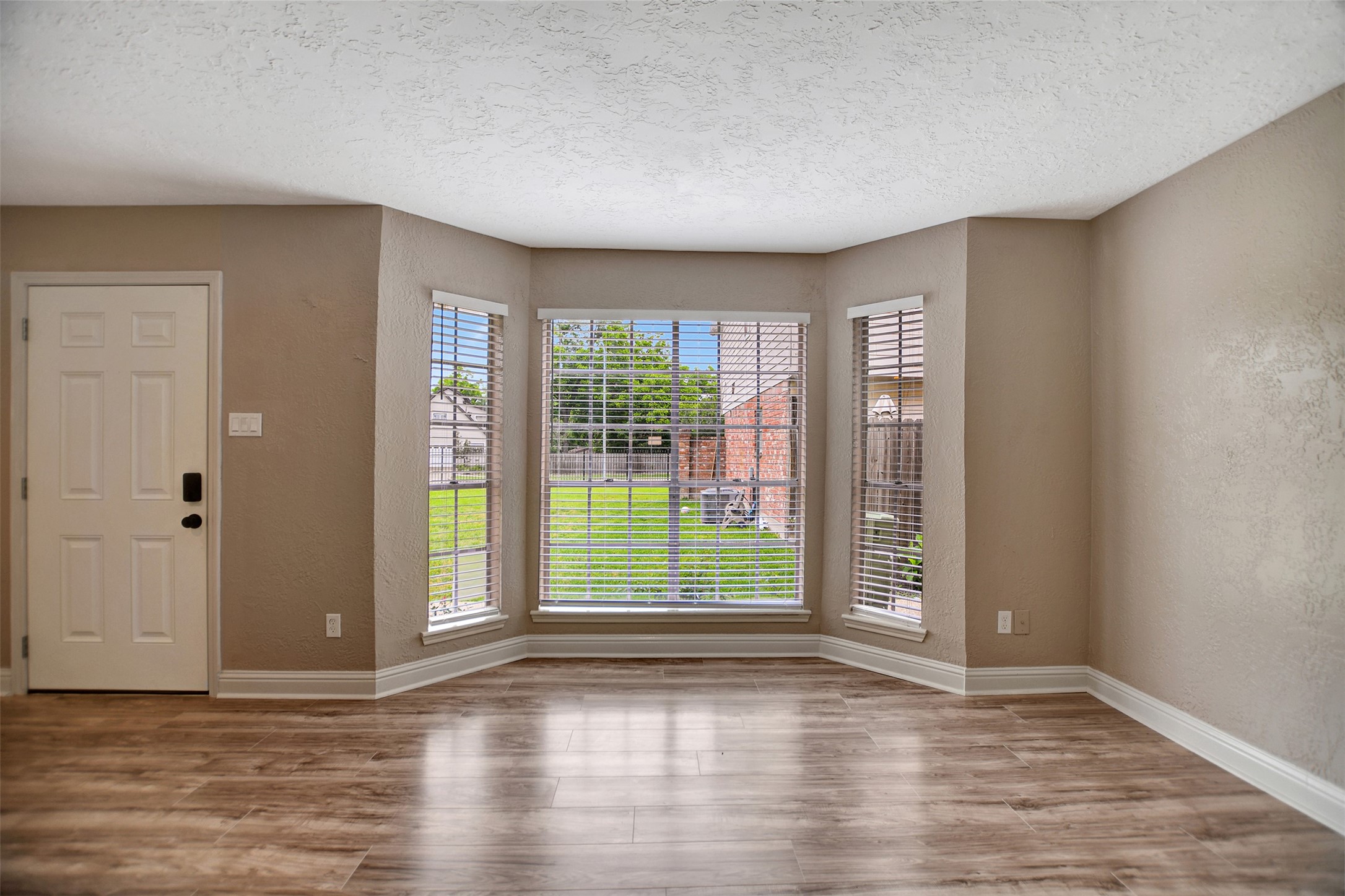 3826 Willow Springs Lane, Unit 3826 Houston, TX 77080 - Photo 9 of 43 a view of an empty room with wooden floor and a window