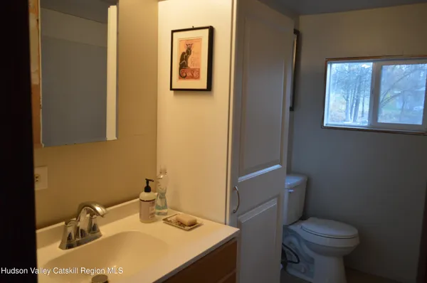 a bathroom with a sink toilet and a mirror