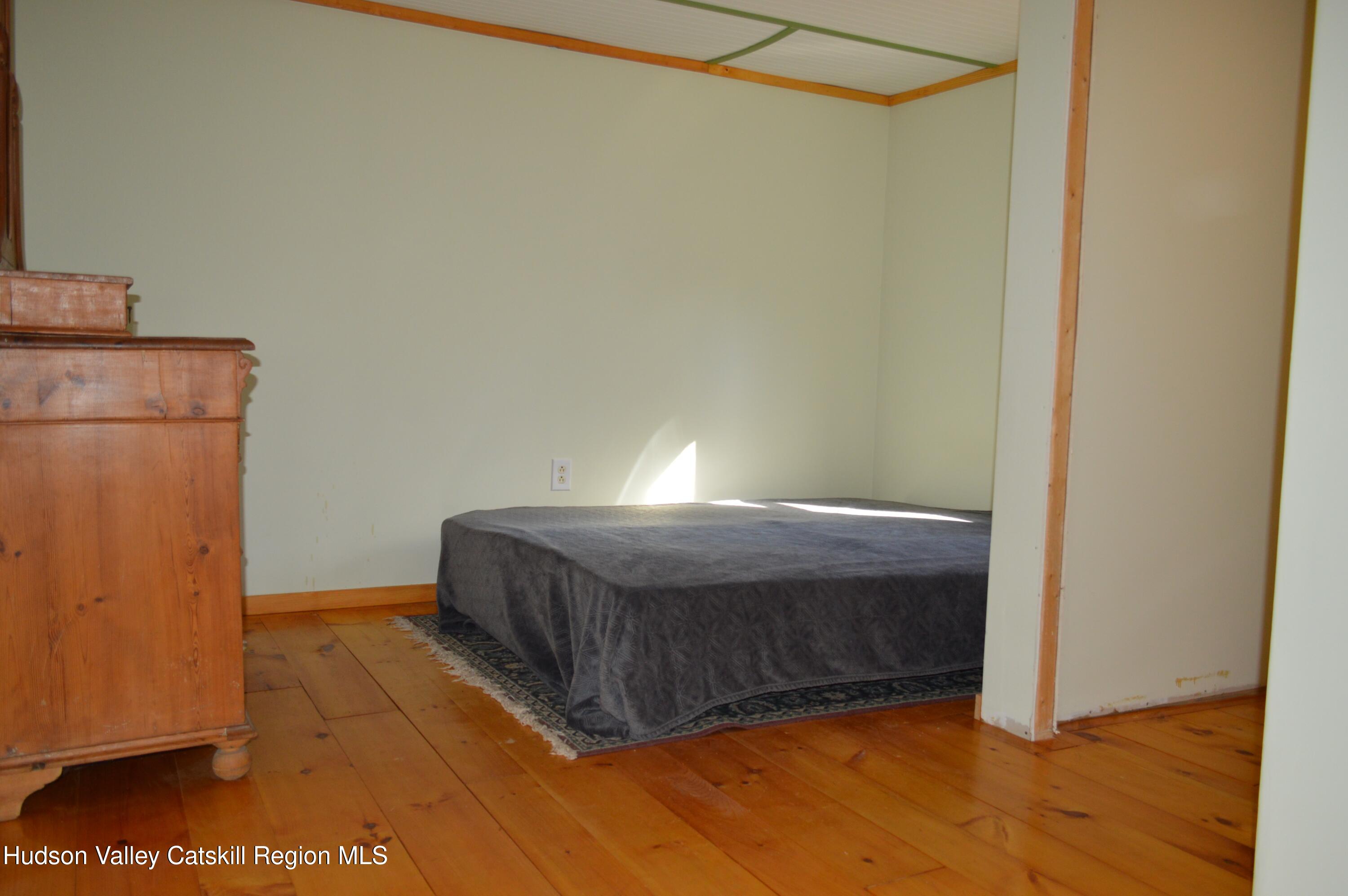 100 Meadow Lane Cairo, NY 12413 - Photo 15 of 18 a bedroom with a bed and wooden floor