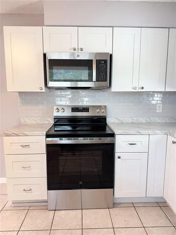 a kitchen with stainless steel appliances granite countertop a stove and a microwave